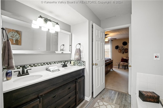 bathroom featuring decorative backsplash, vanity, a textured ceiling, and hardwood / wood-style flooring