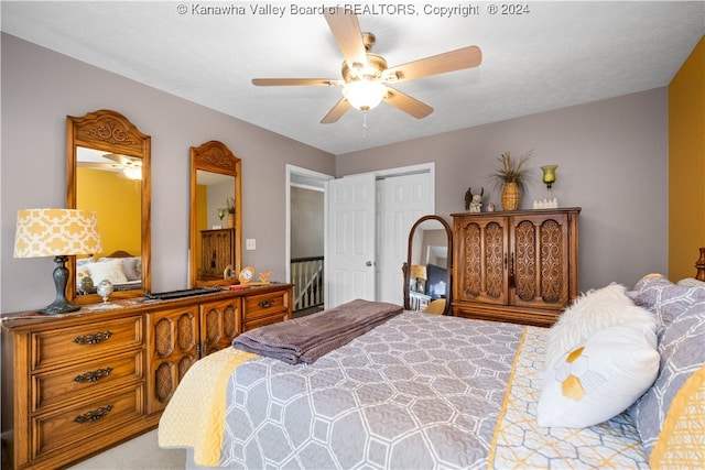 carpeted bedroom with ceiling fan, a closet, and a textured ceiling