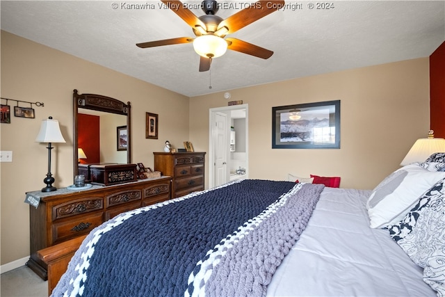 carpeted bedroom with ceiling fan and a textured ceiling