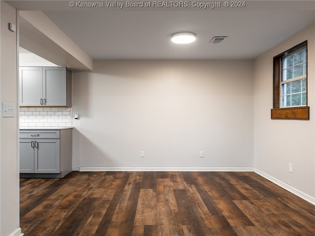 interior space with decorative backsplash, dark hardwood / wood-style flooring, and gray cabinetry