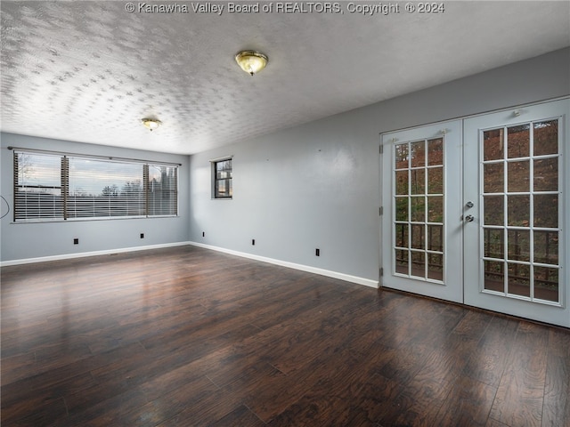 unfurnished room featuring dark hardwood / wood-style floors, a textured ceiling, and french doors