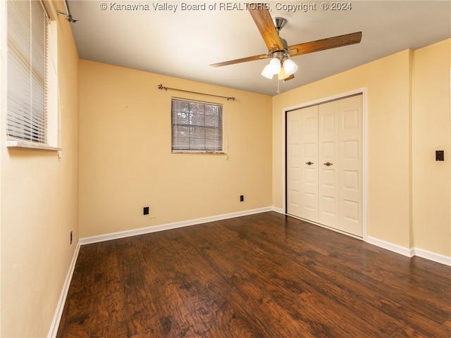 unfurnished bedroom with dark hardwood / wood-style floors, ceiling fan, and a closet