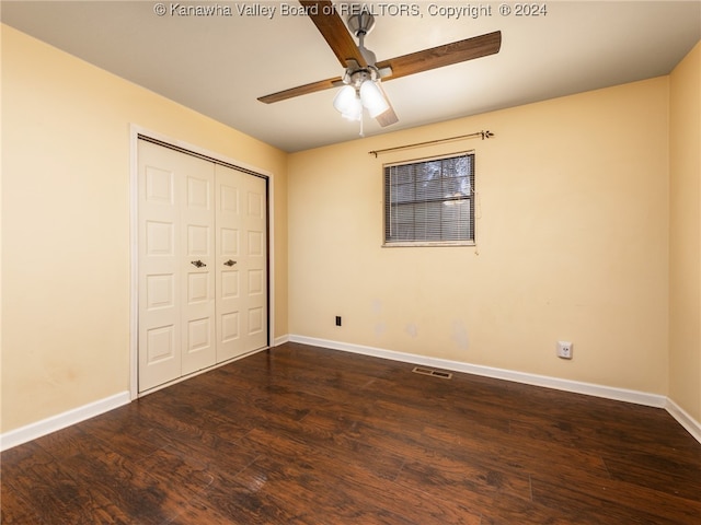 unfurnished bedroom featuring ceiling fan, dark wood-type flooring, and a closet