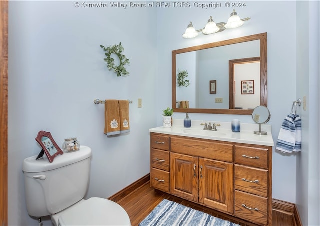 bathroom featuring vanity, hardwood / wood-style flooring, and toilet