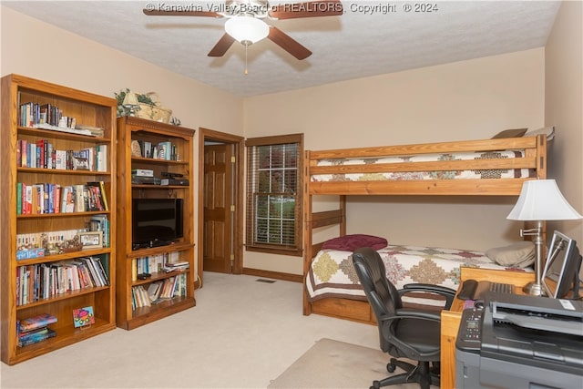 carpeted bedroom with a textured ceiling and ceiling fan