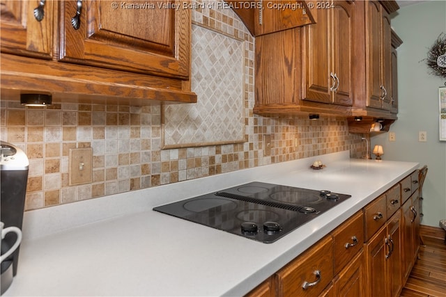 kitchen with backsplash, black electric cooktop, and hardwood / wood-style floors