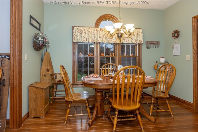 dining space with hardwood / wood-style floors and a chandelier