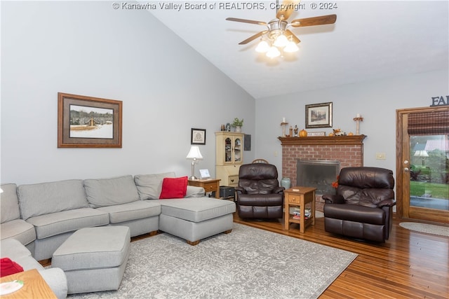 living room with a fireplace, ceiling fan, hardwood / wood-style floors, and high vaulted ceiling