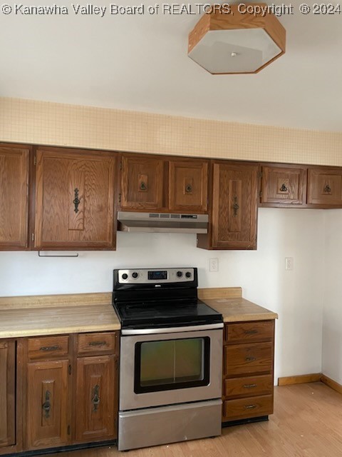 kitchen with light hardwood / wood-style floors and stainless steel electric range oven