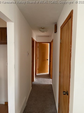 hallway with dark colored carpet