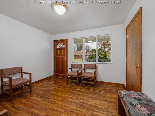 sitting room featuring dark hardwood / wood-style flooring and a textured ceiling