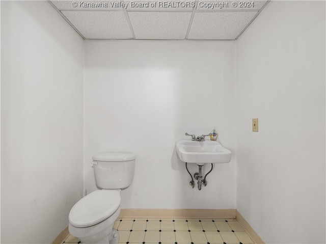 bathroom with sink, a drop ceiling, and toilet