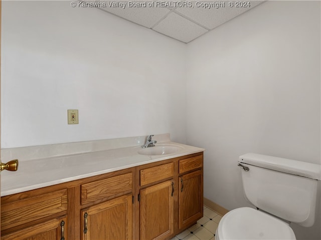 bathroom featuring a paneled ceiling, vanity, and toilet