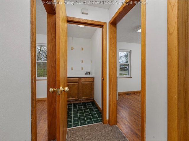 corridor with hardwood / wood-style floors, a textured ceiling, and sink