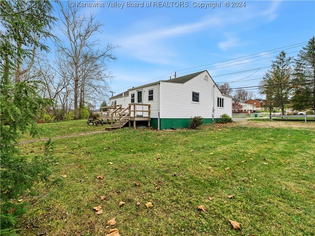 view of side of home with a yard and a wooden deck