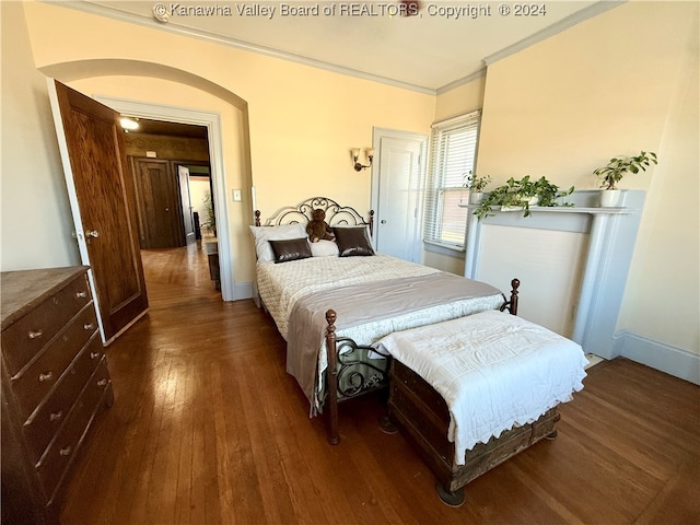 bedroom with crown molding and dark wood-type flooring