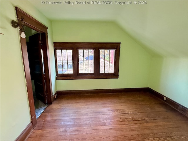 additional living space featuring lofted ceiling and wood-type flooring