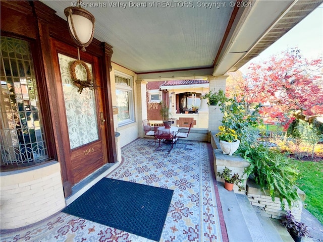 view of exterior entry featuring covered porch