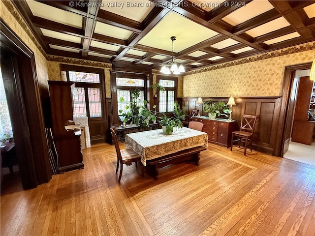 dining room with beamed ceiling, a notable chandelier, light wood-type flooring, and coffered ceiling