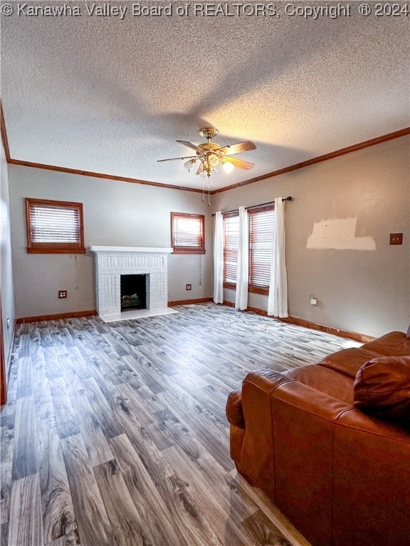 living room featuring hardwood / wood-style floors, a textured ceiling, ceiling fan, and ornamental molding