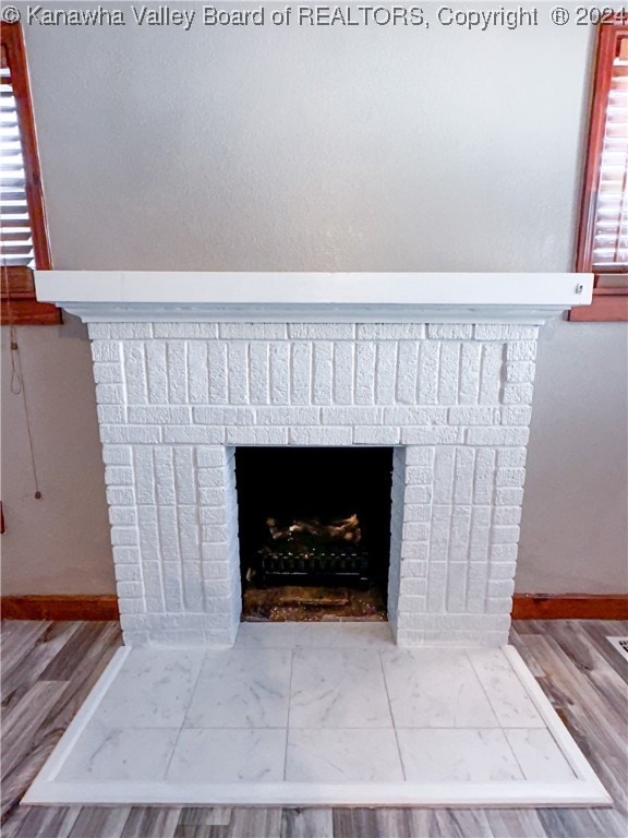 details with wood-type flooring and a brick fireplace