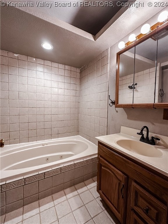 bathroom with tile patterned floors, vanity, tiled shower / bath combo, and a textured ceiling