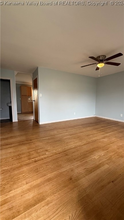 empty room featuring light wood-type flooring and ceiling fan