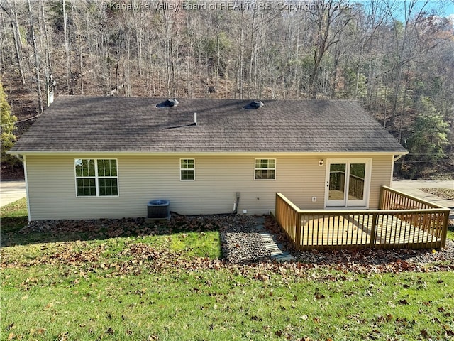 back of property featuring a lawn, a wooden deck, and central AC