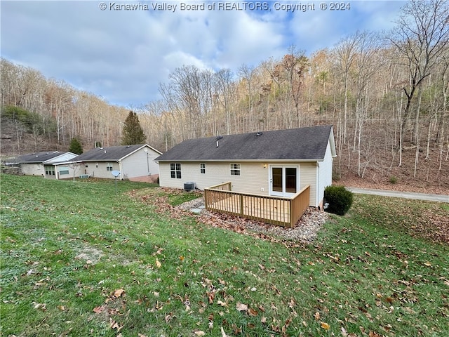 rear view of property with a yard and a deck