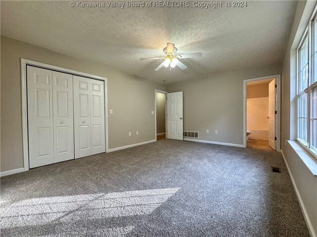 unfurnished bedroom with multiple windows, ceiling fan, and a textured ceiling