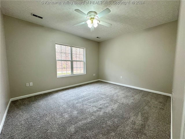 carpeted spare room with ceiling fan and a textured ceiling