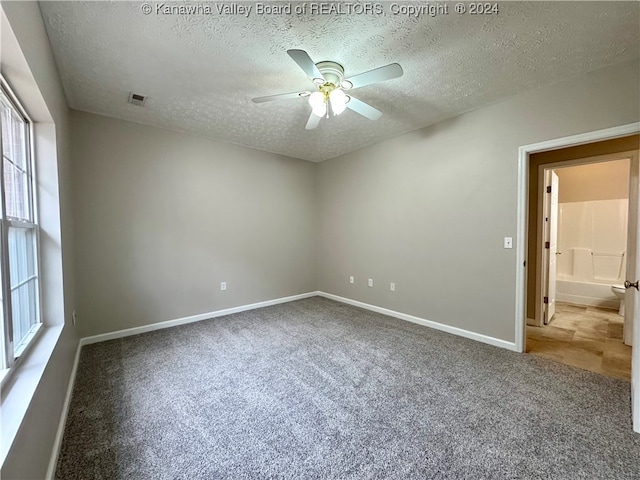 unfurnished room with ceiling fan, carpet floors, and a textured ceiling