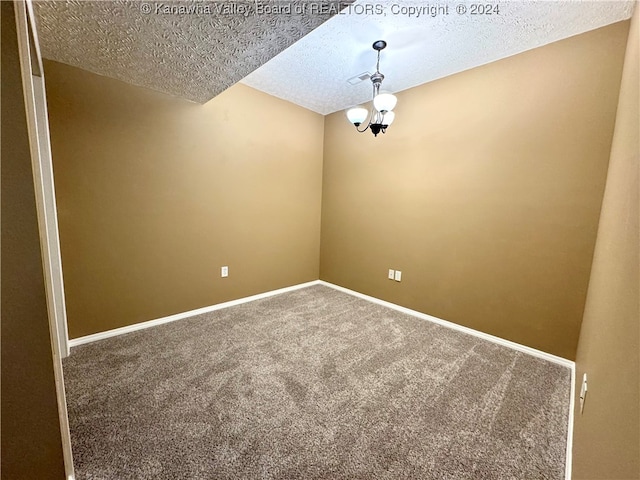 carpeted empty room with a textured ceiling