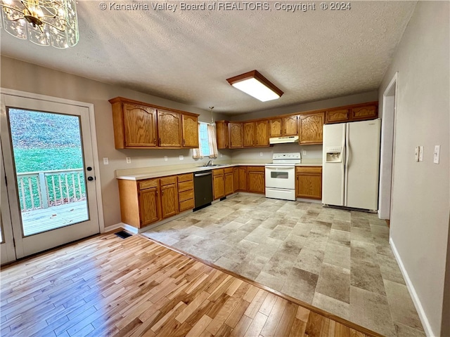 kitchen featuring white appliances, light hardwood / wood-style floors, and a wealth of natural light