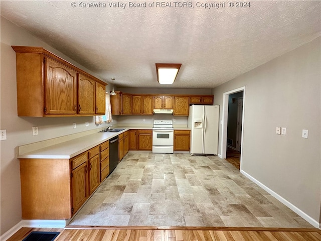 kitchen with a textured ceiling, white appliances, light hardwood / wood-style floors, and sink