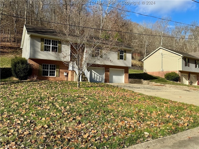 raised ranch with a garage and a front lawn