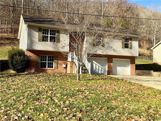 raised ranch featuring a front lawn and a garage