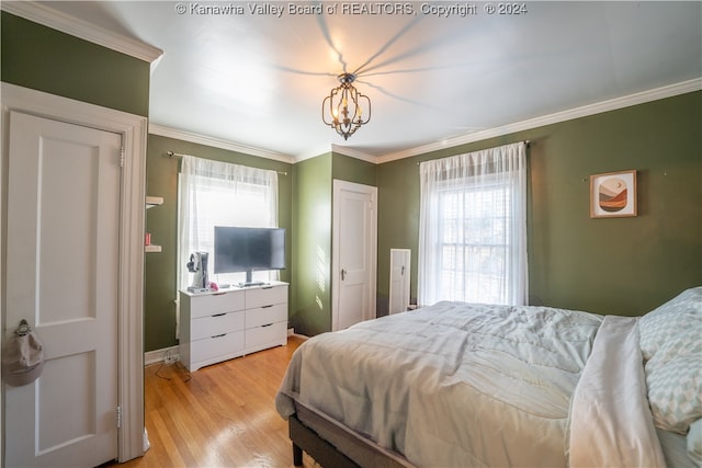 bedroom with a chandelier, light hardwood / wood-style flooring, multiple windows, and crown molding