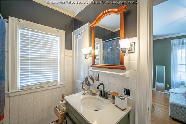 bathroom featuring vanity, wood-type flooring, ornamental molding, and tile walls