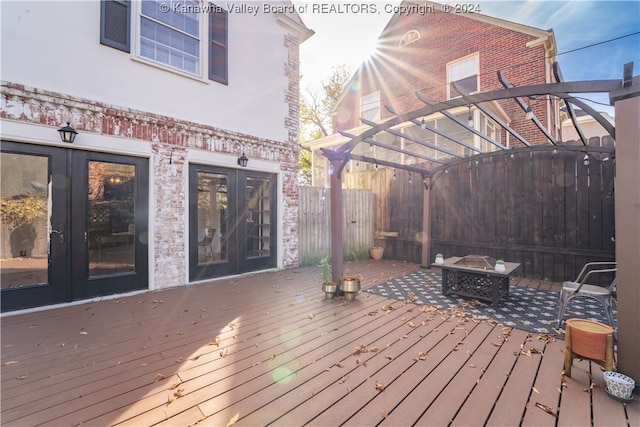 wooden deck with french doors and an outdoor fire pit