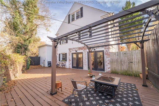 wooden deck with a fire pit and a pergola