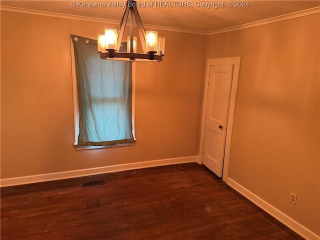 spare room with crown molding, dark hardwood / wood-style floors, and an inviting chandelier