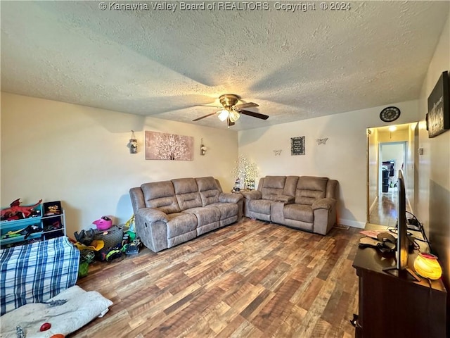 living room featuring ceiling fan, hardwood / wood-style floors, and a textured ceiling