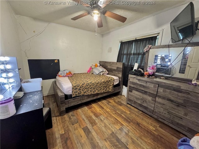 bedroom with a textured ceiling, dark hardwood / wood-style flooring, and ceiling fan