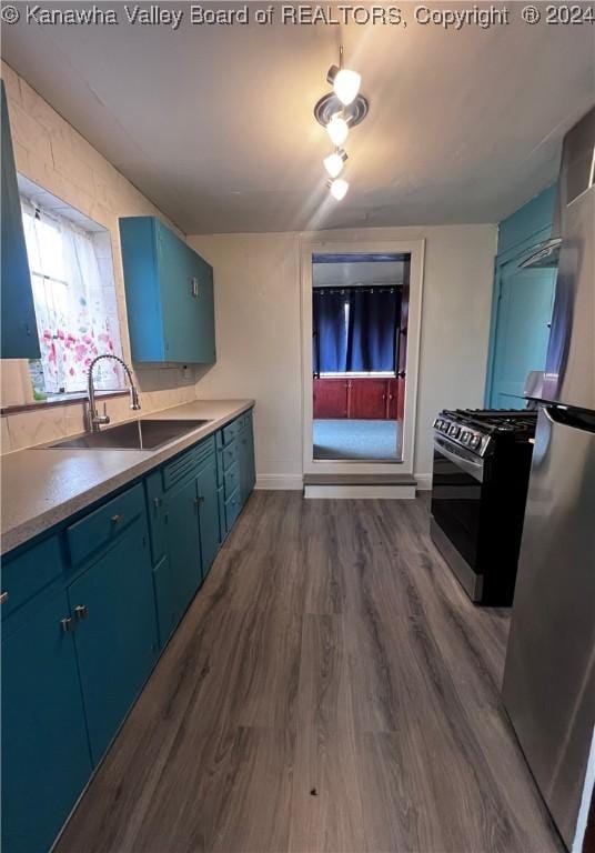 kitchen featuring blue cabinetry, stainless steel appliances, dark wood-type flooring, and sink