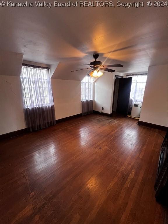 bonus room with ceiling fan and dark hardwood / wood-style floors