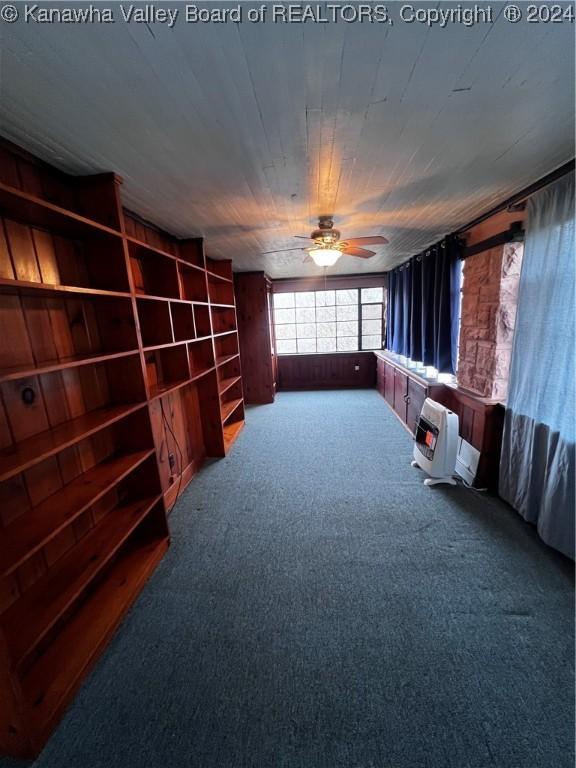 carpeted cinema featuring ceiling fan and heating unit