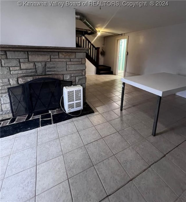 interior space with tile patterned floors and a stone fireplace