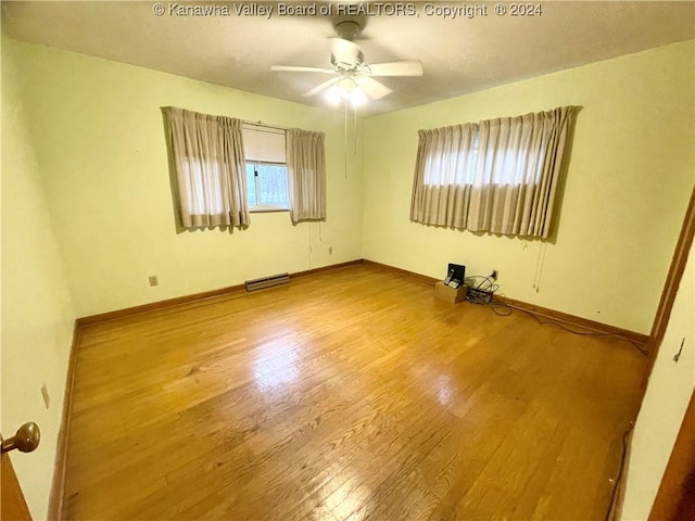 unfurnished room with a wealth of natural light, hardwood / wood-style floors, and ceiling fan