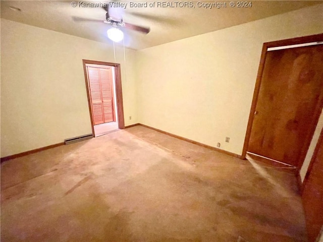 carpeted empty room featuring ceiling fan and a baseboard radiator